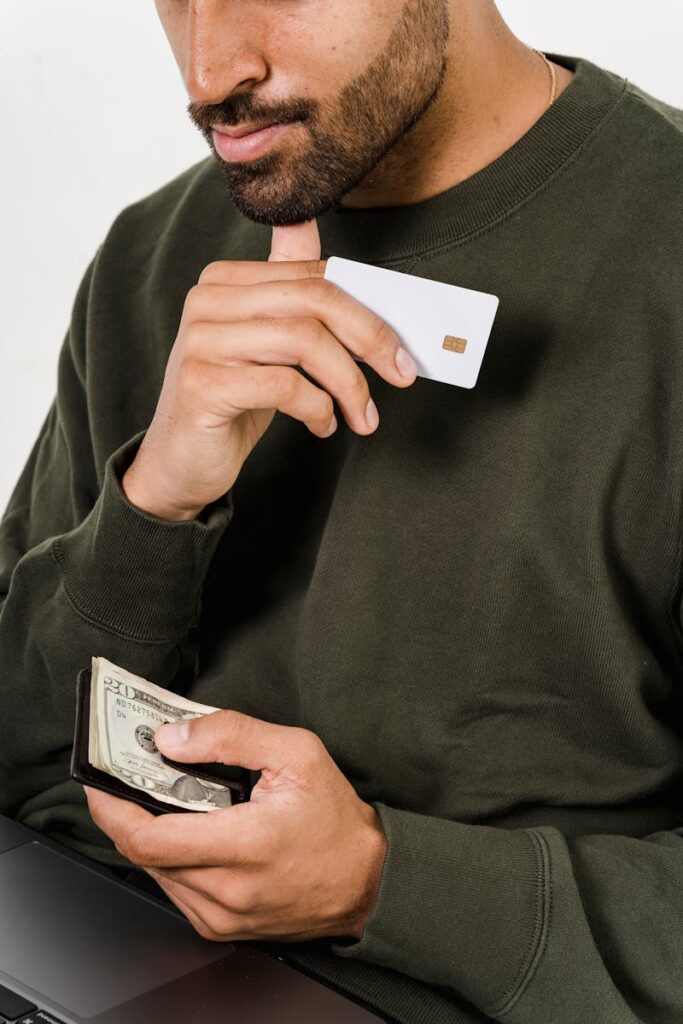 Man holding a wallet filled with dollar bills while reviewing specialized loan services for his business.